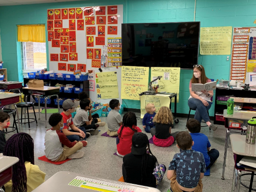 Children's Librarian reading to a classroom of school children.