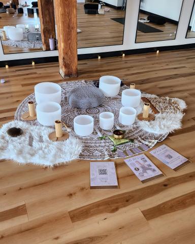White Frosted Singing bowls set up in a half circle around a grey meditation cushion.