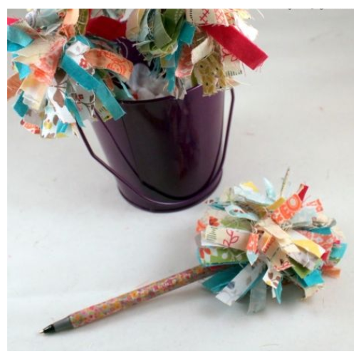 fabric nestled on top of pen with colorful tape wrapped around it