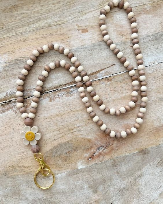 Beaded lanyard with flower bead and a lobster claw hook with a split ring.