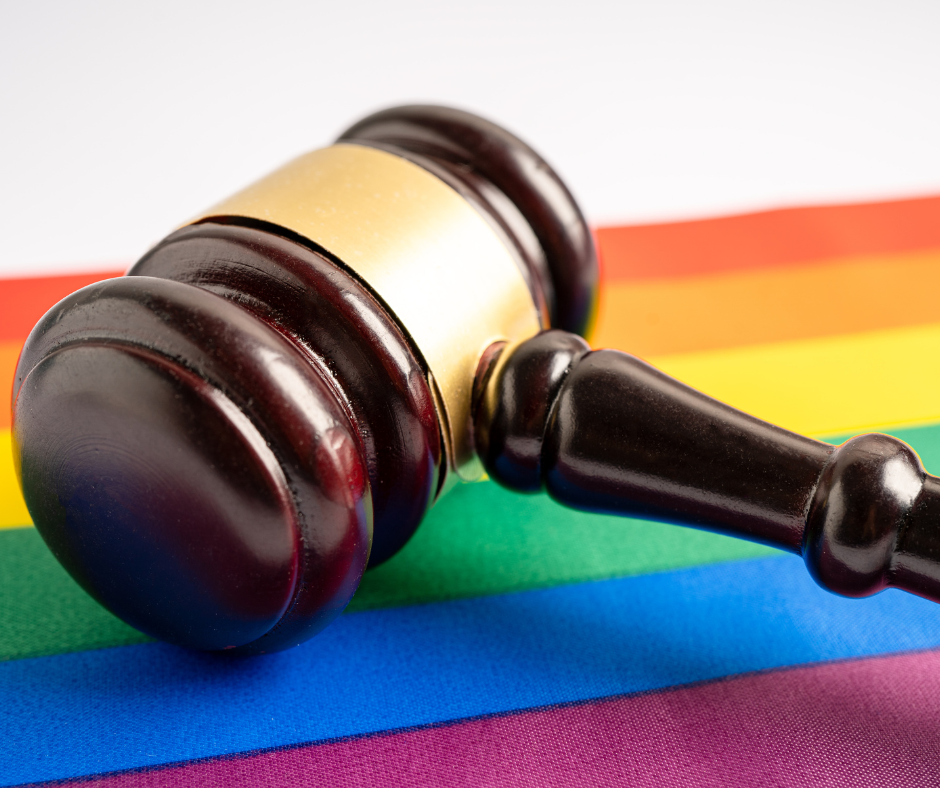 A gavel on a rainbow Pride flag.